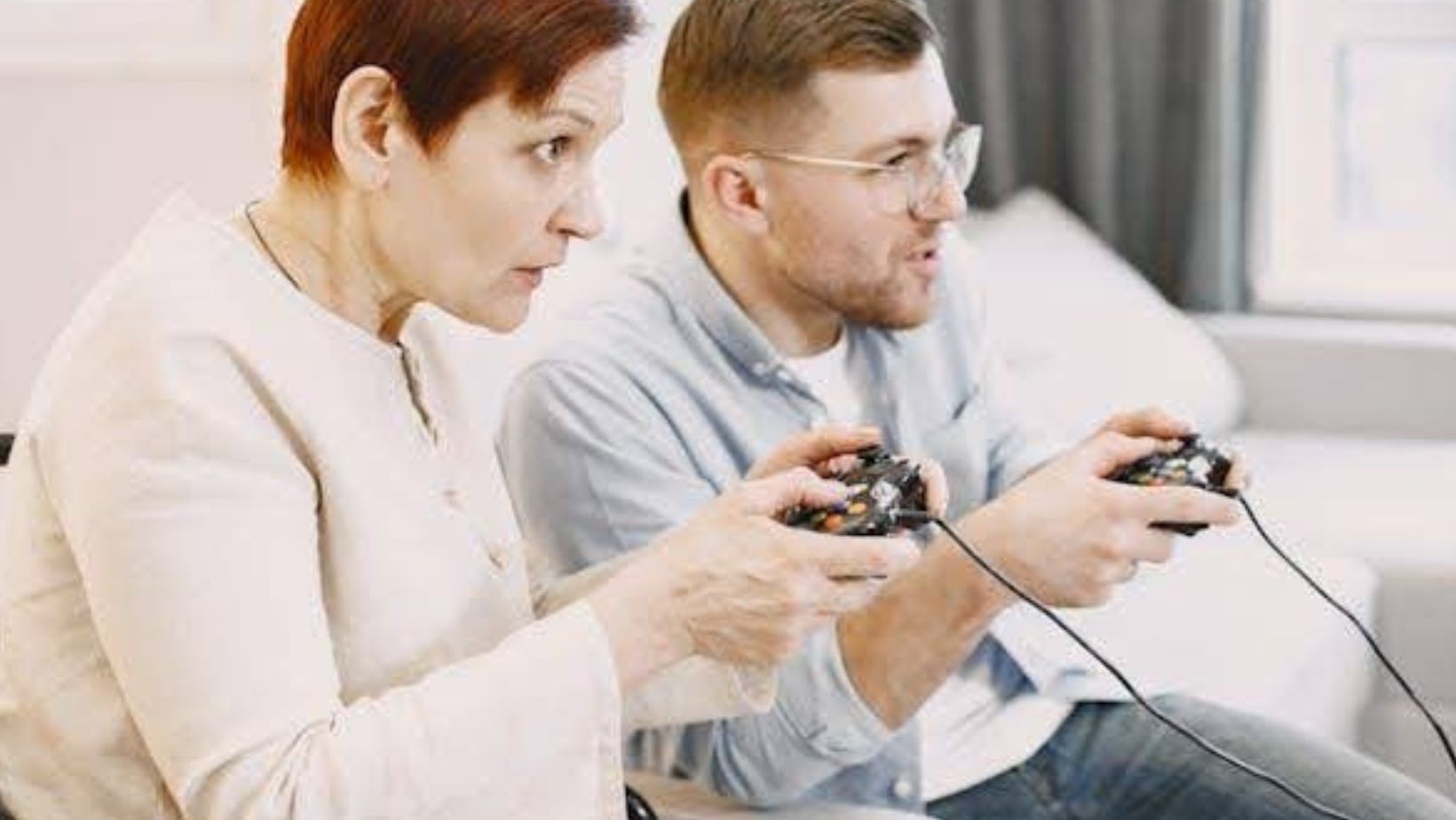 A woman and a man are focused on playing a video game