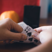 Hands holding Ace and 10 of spades playing cards in a blackjack hand